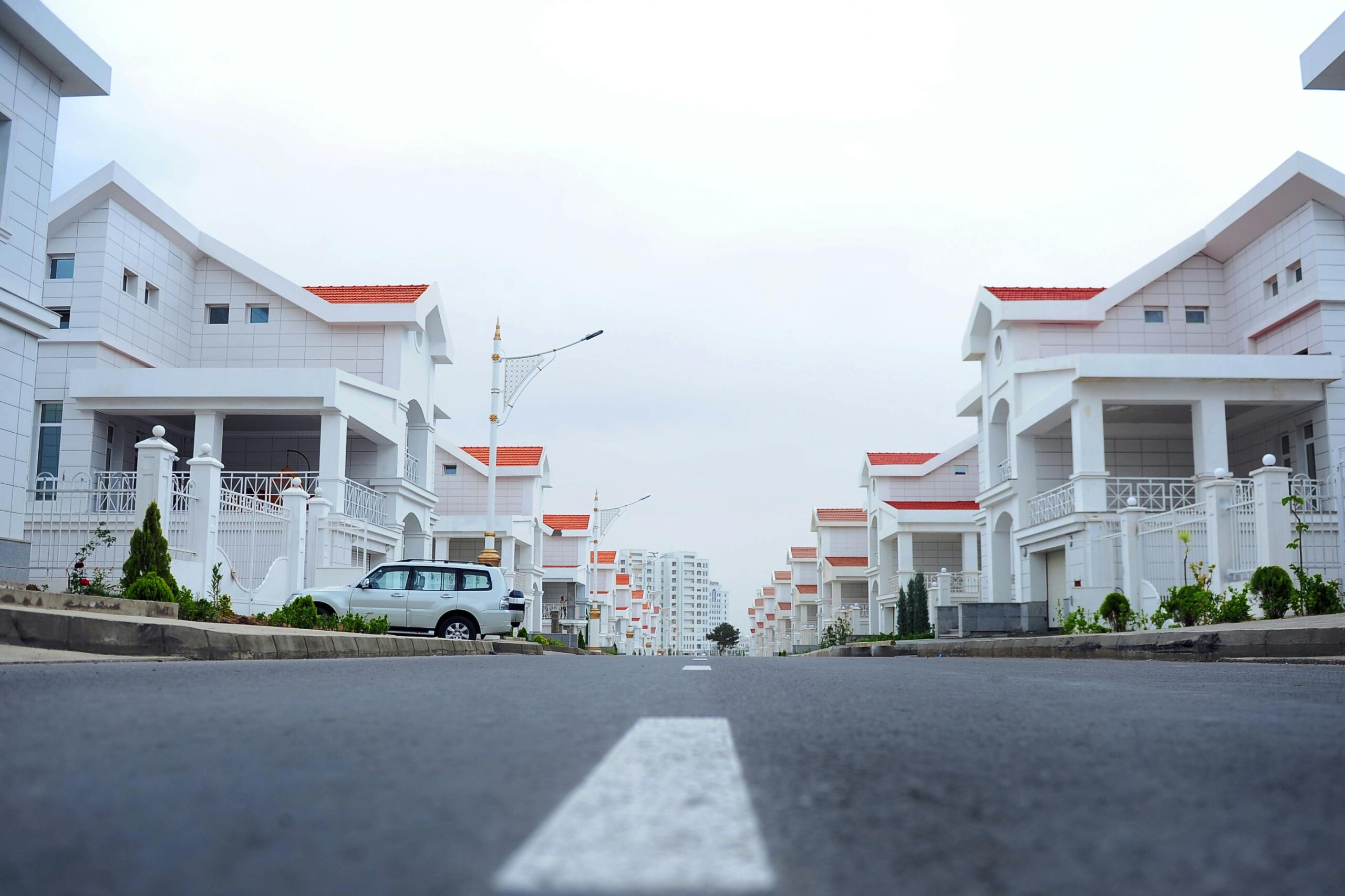 Modern luxury houses line a calm street in Ashgabat, Turkmenistan.